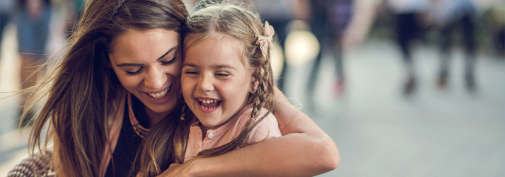 Chiropractic Park Ridge IL An Exhausted Mom's Survival Guide A mother and daughter smiling. The mother has her arms around the young girl
